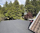 New flat roof covering next to a tiled roof